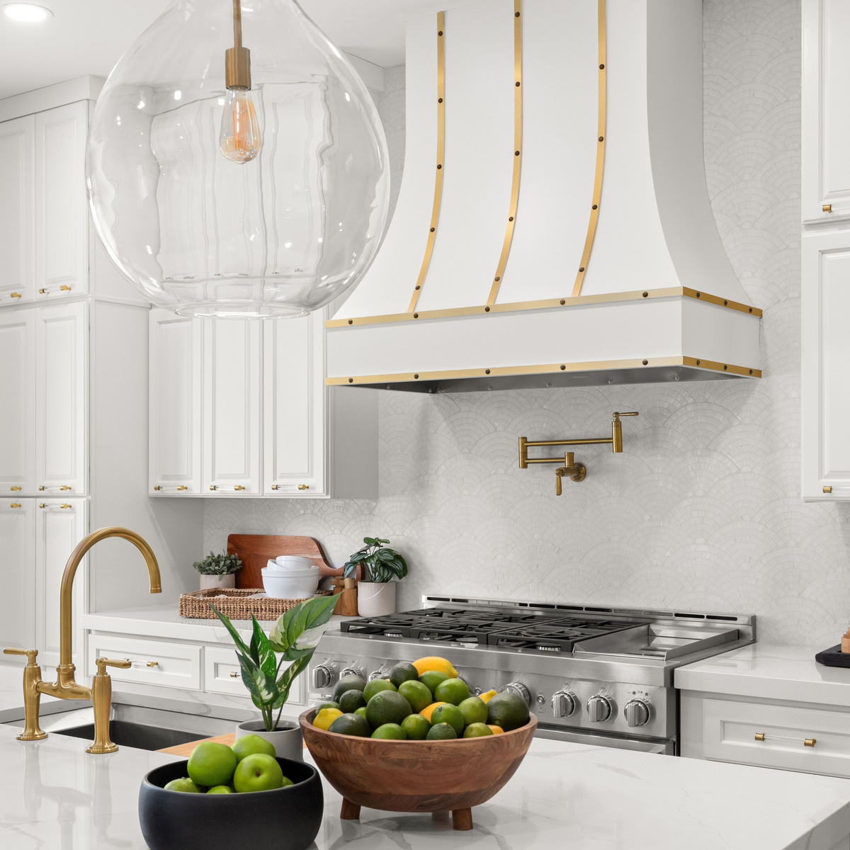 White and gold range hood in white decorated kitchen