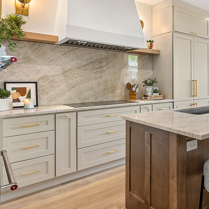 Image of Nantucket Bluff kitchen cabinets along with white hood and a wooden island with marble countertops